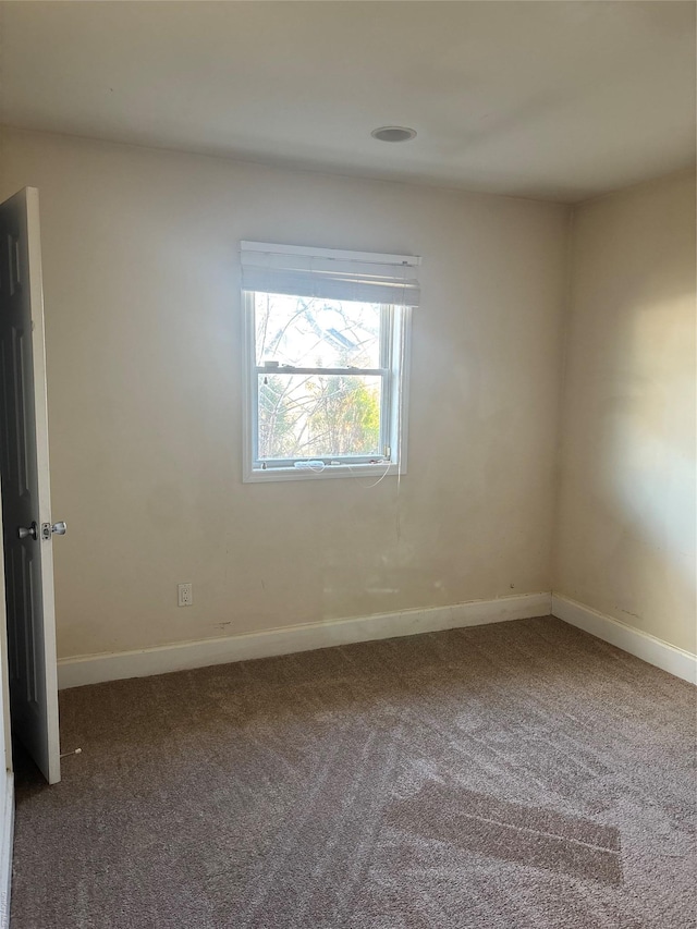 carpeted empty room with baseboards