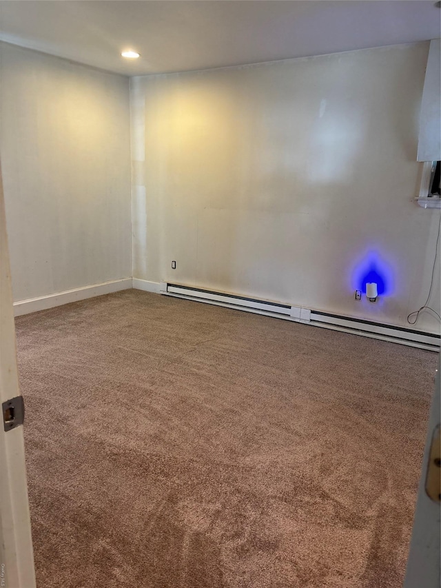 carpeted spare room featuring baseboards and a baseboard heating unit