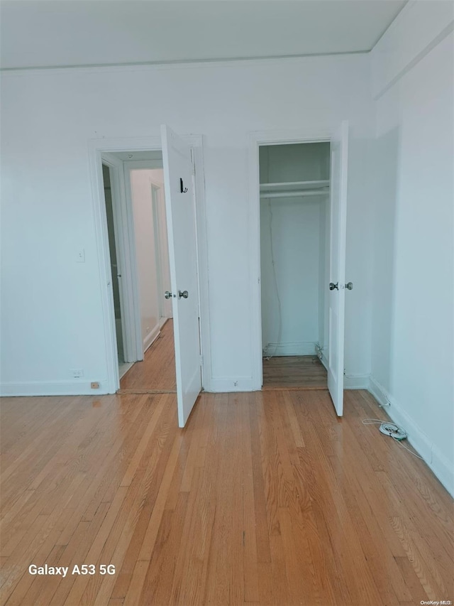 unfurnished bedroom with light hardwood / wood-style floors and a closet