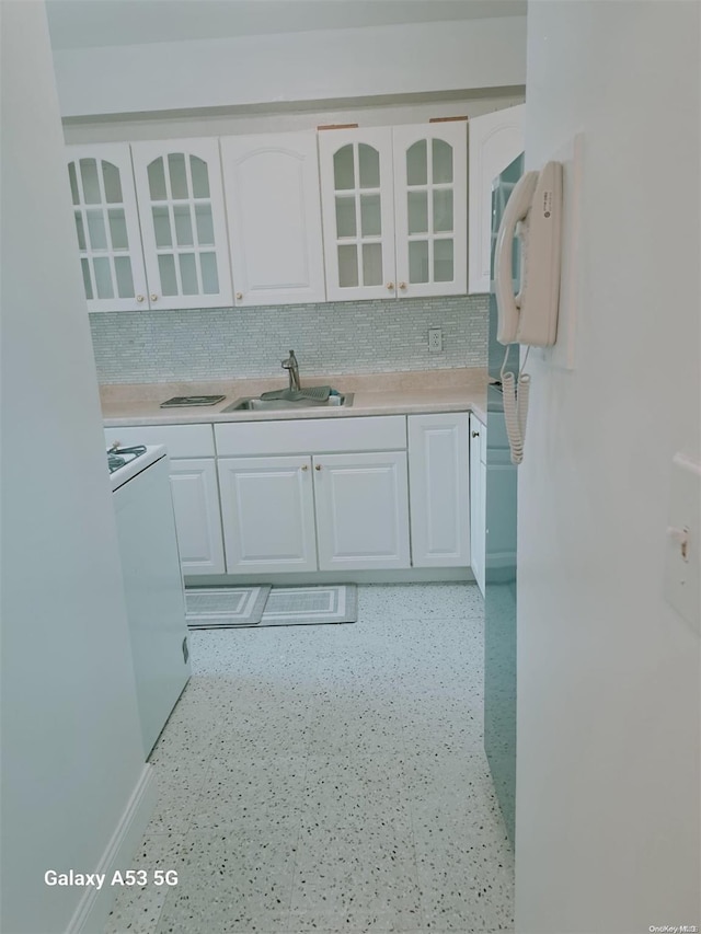 kitchen with decorative backsplash, sink, white cabinets, and white electric stove