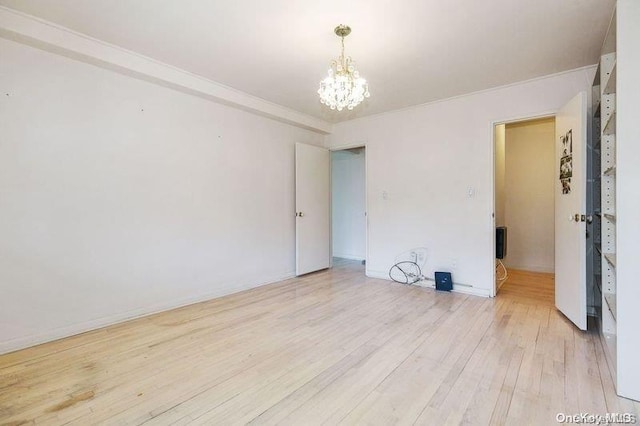 unfurnished room with a chandelier, light hardwood / wood-style floors, and ornamental molding