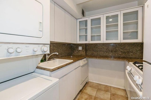 laundry area with stacked washer / dryer and sink