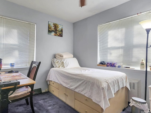 carpeted bedroom featuring radiator and ceiling fan