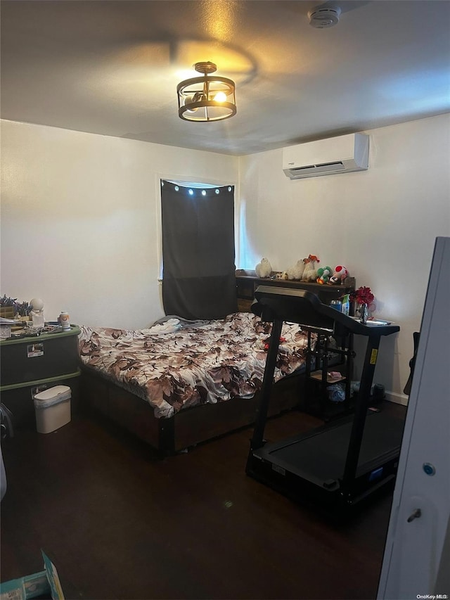 bedroom with dark hardwood / wood-style flooring and a wall mounted air conditioner