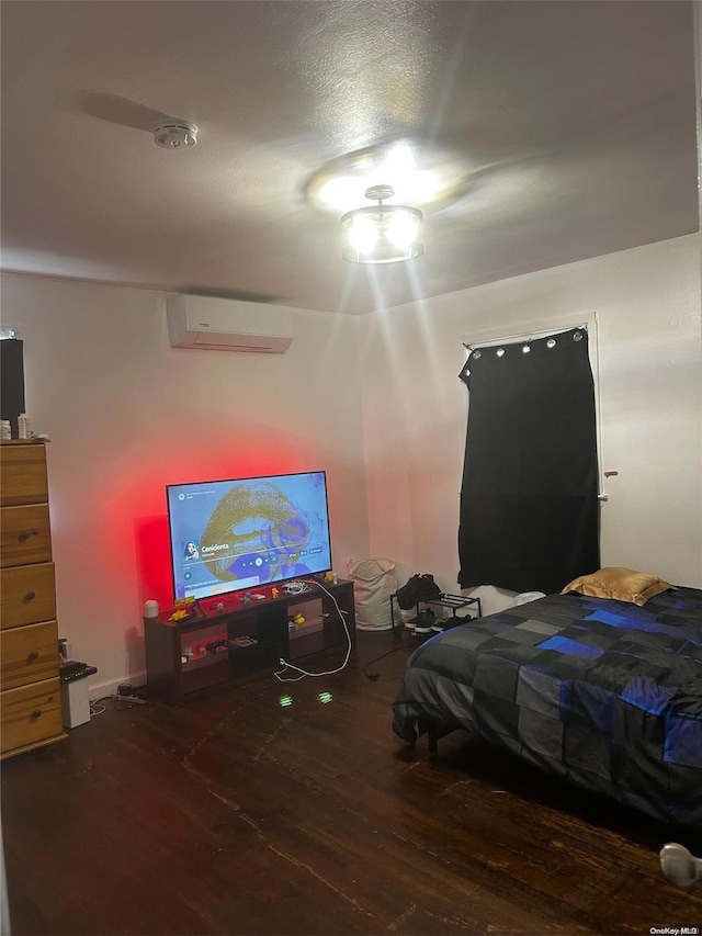 bedroom featuring wood-type flooring and an AC wall unit