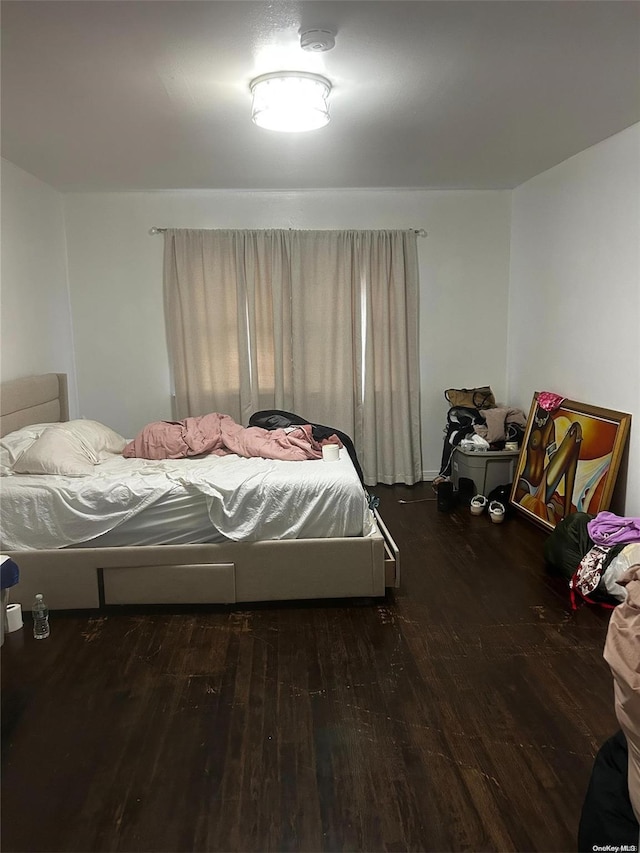 bedroom with dark hardwood / wood-style floors