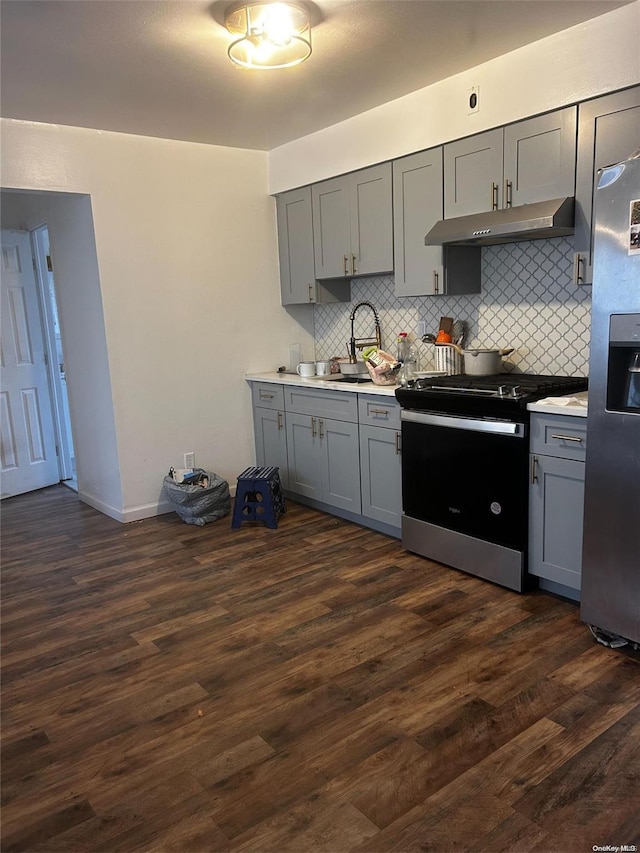 kitchen with backsplash, sink, dark hardwood / wood-style floors, gray cabinets, and stainless steel appliances