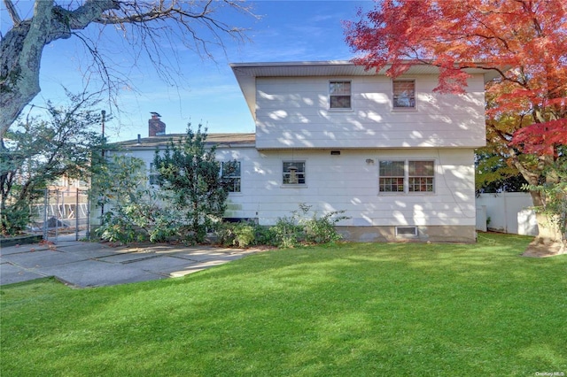 rear view of property with a yard