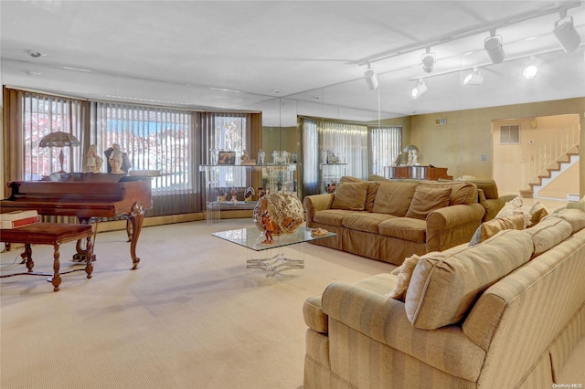 carpeted living room with track lighting