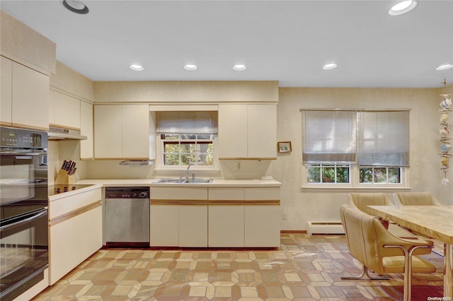 kitchen featuring sink, baseboard heating, stainless steel dishwasher, double oven, and cream cabinets