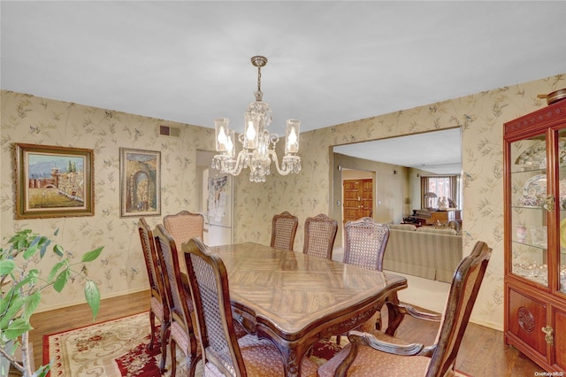 dining area featuring hardwood / wood-style flooring and a notable chandelier