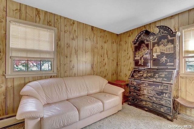 living room with carpet flooring, baseboard heating, and wooden walls