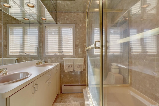 bathroom with vanity, a baseboard radiator, a wealth of natural light, and tile walls