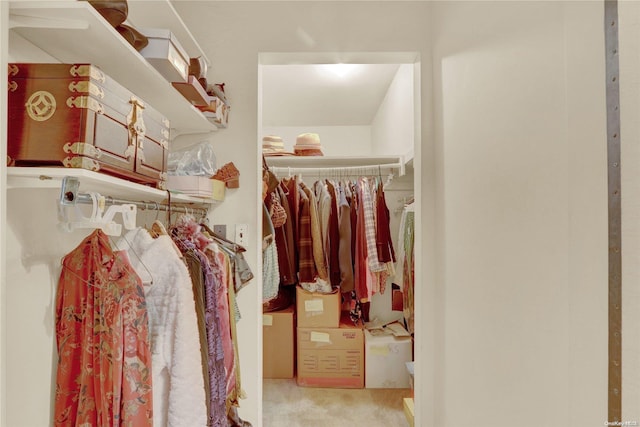 walk in closet featuring light carpet