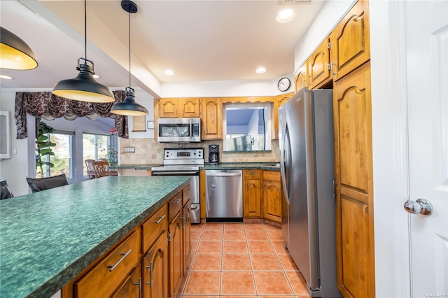 kitchen featuring decorative light fixtures, light tile patterned floors, stainless steel appliances, and tasteful backsplash