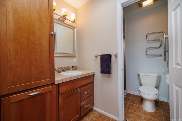 bathroom featuring tile patterned flooring, vanity, toilet, and an enclosed shower