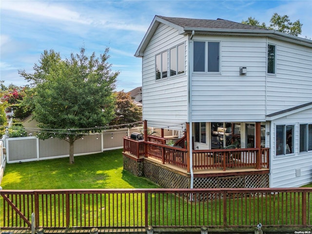 back of property featuring a wooden deck and a yard