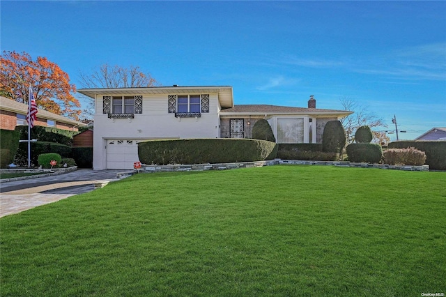 tri-level home featuring a garage and a front yard