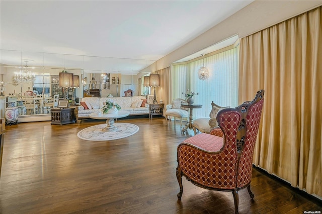 living room with dark hardwood / wood-style flooring and an inviting chandelier