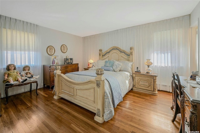 bedroom featuring wood-type flooring and a baseboard heating unit