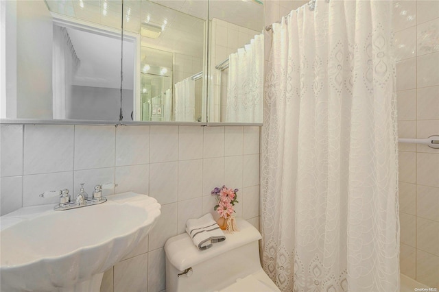 bathroom with backsplash, sink, tile walls, toilet, and curtained shower