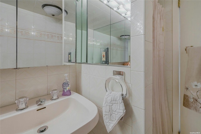 bathroom featuring tasteful backsplash, sink, and tile walls