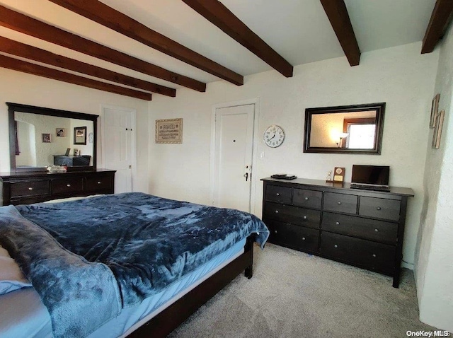 carpeted bedroom featuring beamed ceiling