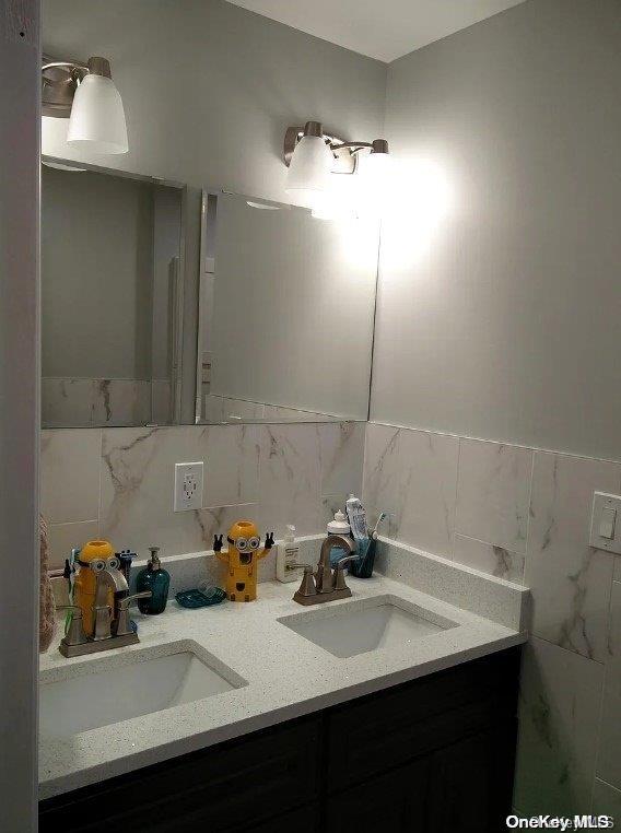 bathroom featuring vanity and tile walls