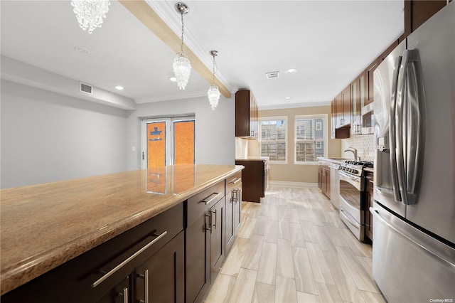 kitchen with pendant lighting, ornamental molding, stainless steel appliances, and an inviting chandelier