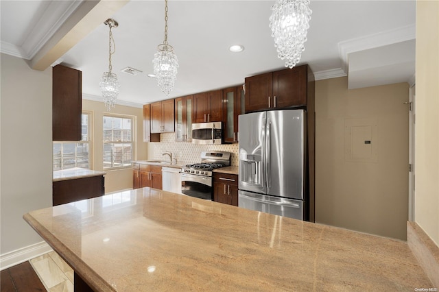 kitchen featuring pendant lighting, dark hardwood / wood-style floors, ornamental molding, appliances with stainless steel finishes, and a chandelier