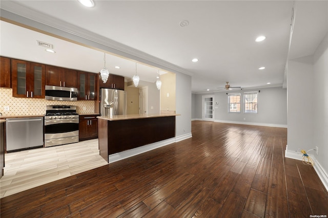 kitchen featuring pendant lighting, ceiling fan, light hardwood / wood-style floors, and appliances with stainless steel finishes