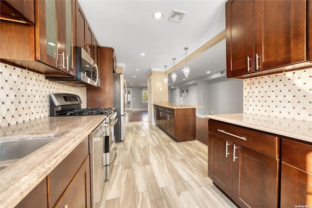 kitchen featuring light stone counters, ornamental molding, stainless steel appliances, and light hardwood / wood-style flooring