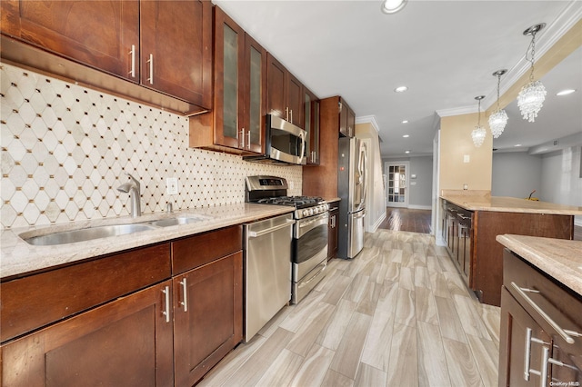 kitchen with light stone countertops, stainless steel appliances, crown molding, sink, and decorative light fixtures