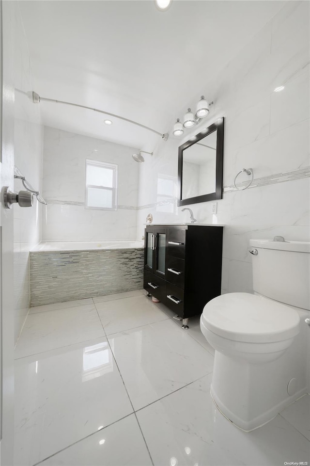 full bathroom featuring tiled shower / bath, vanity, toilet, and tile walls