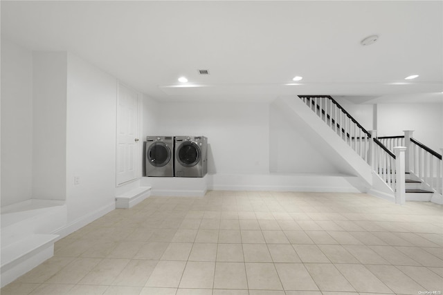 washroom with light tile patterned floors and washing machine and clothes dryer