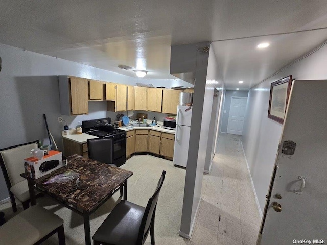 kitchen featuring white fridge, light brown cabinetry, and black / electric stove