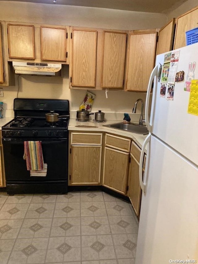 kitchen with sink, light brown cabinets, black range with gas stovetop, ventilation hood, and white fridge