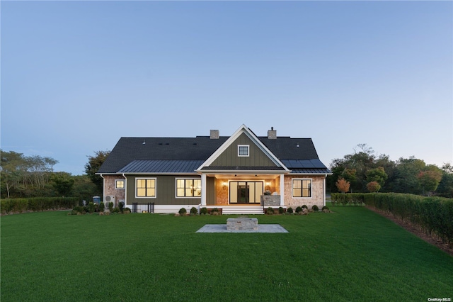 back of house with a lawn, solar panels, and a porch