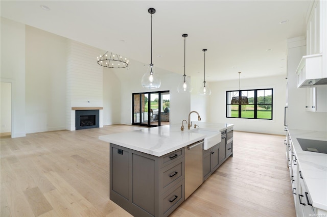 kitchen with dishwasher, white cabinetry, sink, and a wealth of natural light