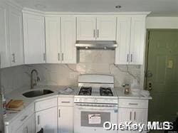 kitchen with backsplash, white cabinetry, white range with gas stovetop, and sink