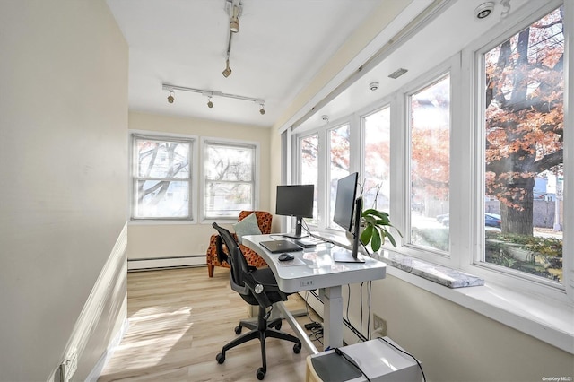 home office featuring baseboard heating, rail lighting, and light hardwood / wood-style floors