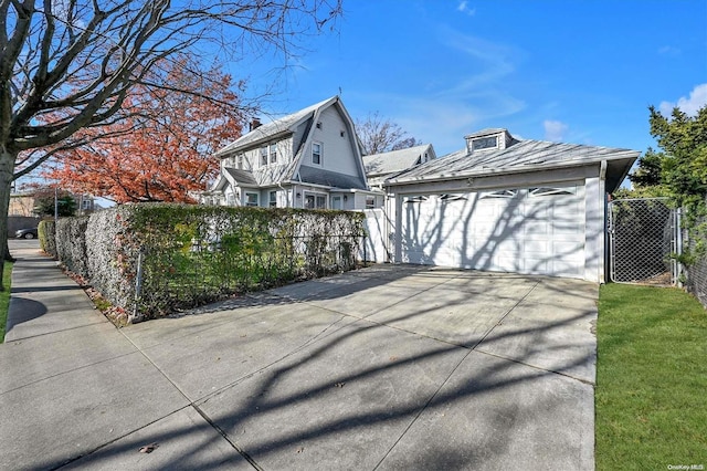 view of side of property with a garage and an outbuilding