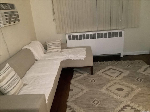 bedroom with a wall mounted air conditioner and radiator heating unit