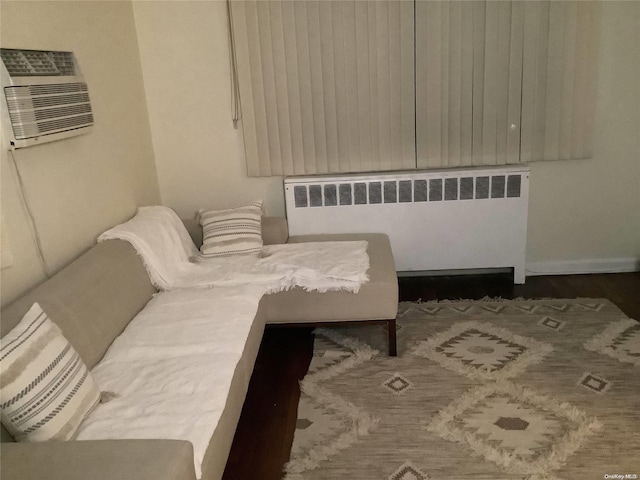 living area featuring an AC wall unit and radiator