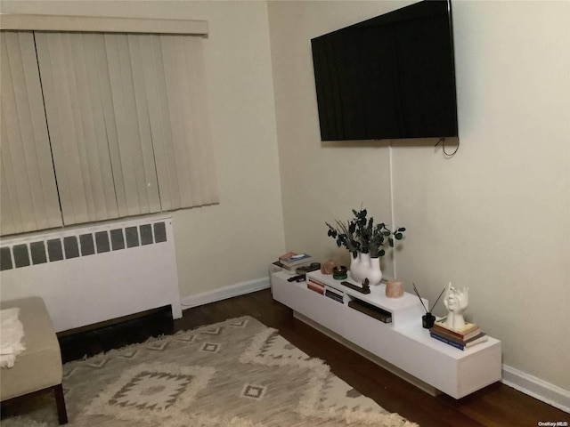 interior space with radiator heating unit and dark hardwood / wood-style flooring