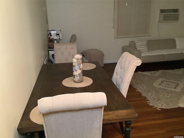 dining area featuring a wall mounted air conditioner and dark hardwood / wood-style floors