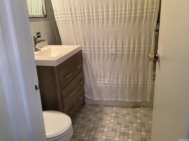 full bathroom featuring shower / bath combo, backsplash, toilet, vanity, and tile walls