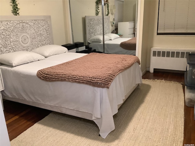 bedroom featuring radiator heating unit, a closet, and hardwood / wood-style floors