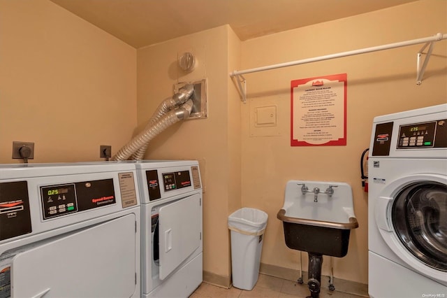 laundry room with independent washer and dryer, sink, and light tile patterned floors