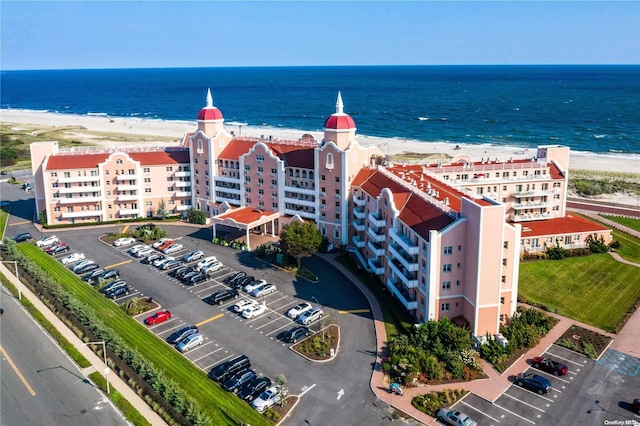 birds eye view of property with a water view and a beach view